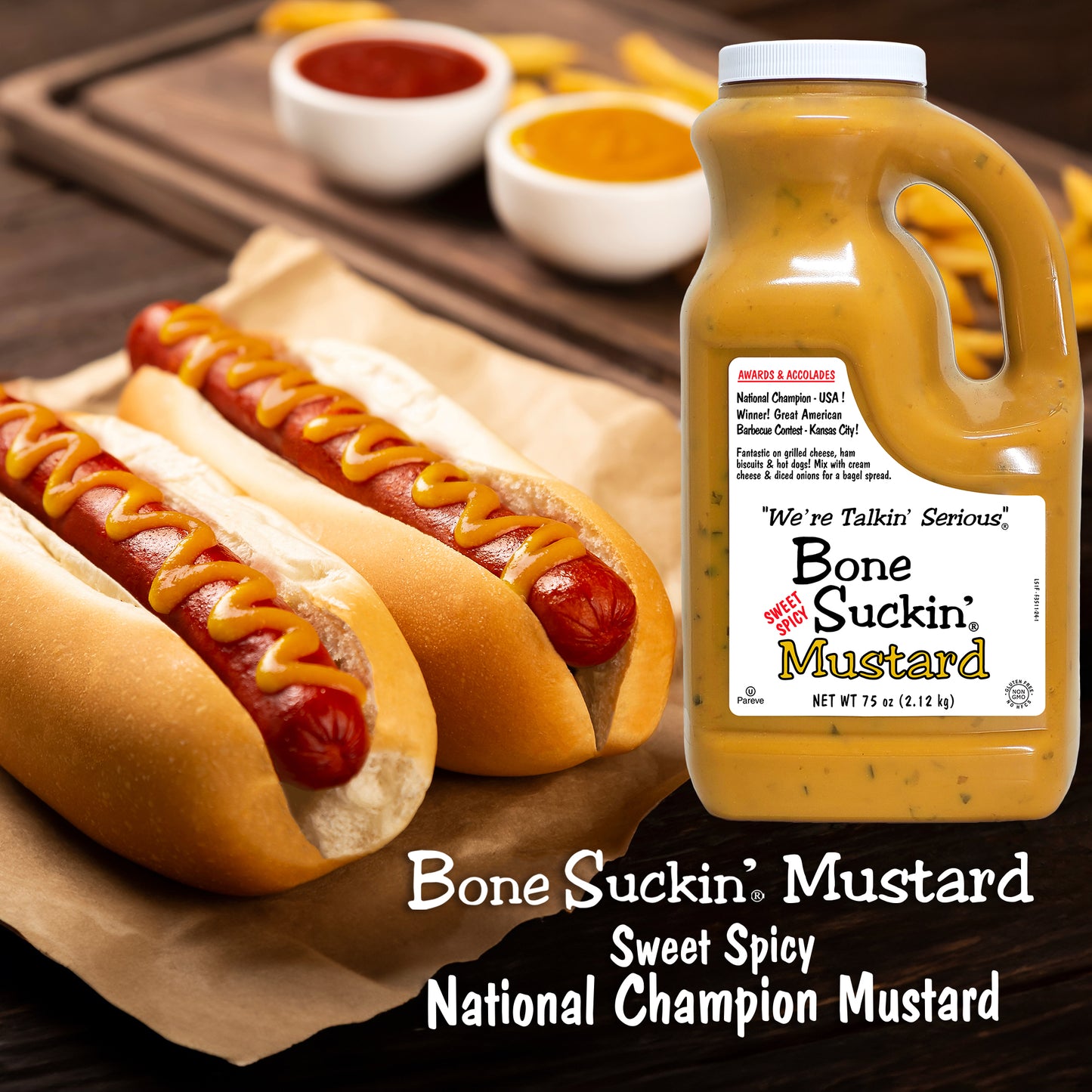 Two hot dogs with mustard and a bottle of Bone Suckin' Mustard on a wooden surface.